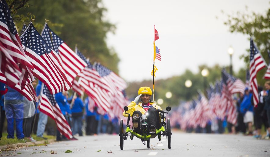 A hand cyclist at the 2015 Marine Corps Marathon in Washington D.C. zips through a mile with fallen veterans honored by wear blue: run to remember. (Photo by Ingrid Barrentine. used with permission)