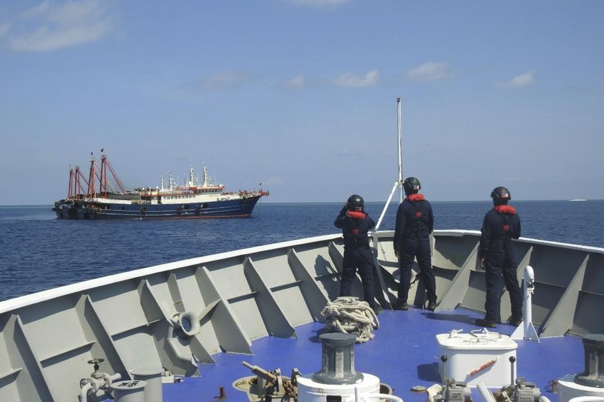 In this April 27, 2021, photo provided by the Philippine Coast Guard, its personnel patrol beside ships said to be Chinese militia vessels at Sabina Shoal in the South China Sea. The Philippine government has protested the Chinese coast guard&#x27;s harassment of Philippine coast guard ships patrolling a disputed shoal in the South China Sea, the Department of Foreign Affairs said Monday, May 3. (Philippine Coast Guard via AP)