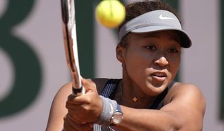 Japan&#39;s Naomi Osaka returns the ball to Romania&#39;s Patricia Maria Tig during their first round match of the French open tennis tournament at the Roland Garros stadium Sunday, May 30, 2021 in Paris. (AP Photo/Christophe Ena)
