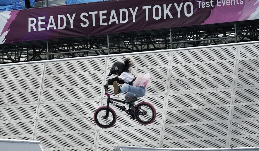 In this May 17, 2021, file photo, a local athlete competes during the Tokyo 2020 Olympic Game Cycling BMX Freestyle test event at Olympic BMX Course of Ariake Urban Sports Park in Tokyo. IOC officials say the Tokyo Olympics will open on July 23 and almost nothing now can stop the games from going forward. (AP Photo/Eugene Hoshiko, File) **FILE**