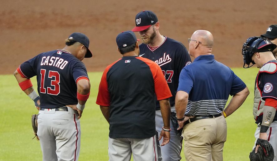 Washington Nationals starting pitcher Stephen Strasburg, center, talks with manager Dave Martinez and a member of the team&#39;s medical staff before exiting a baseball game in then second inning against Atlanta Braves Tuesday, June 1, 2021, in Atlanta. (AP Photo/John Bazemore) **FILE**