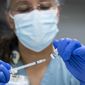 A pharmacy technician at Texas Southern University in Houston prepares a COVID-19 vaccine. (Brett Coomer/Houston Chronicle via AP, File)