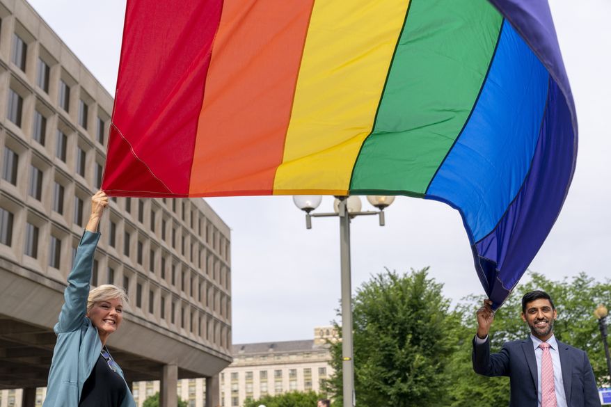 In this file photo, Energy Secretary Jennifer Granholm and Department of Energy Chief of Staff Tarak Shah, right, help raise the Progress Pride Flag outside the Department of Energy in Washington, Wednesday, June 2, 2021. The Department of Defense, meanwhile, is also honoring LGBT Pride month, but its existing ban on service members displaying Pride flags will remain in place, Pentagon spokesman John Kirby told reporters recently. (AP Photo/Andrew Harnik) **FILE**