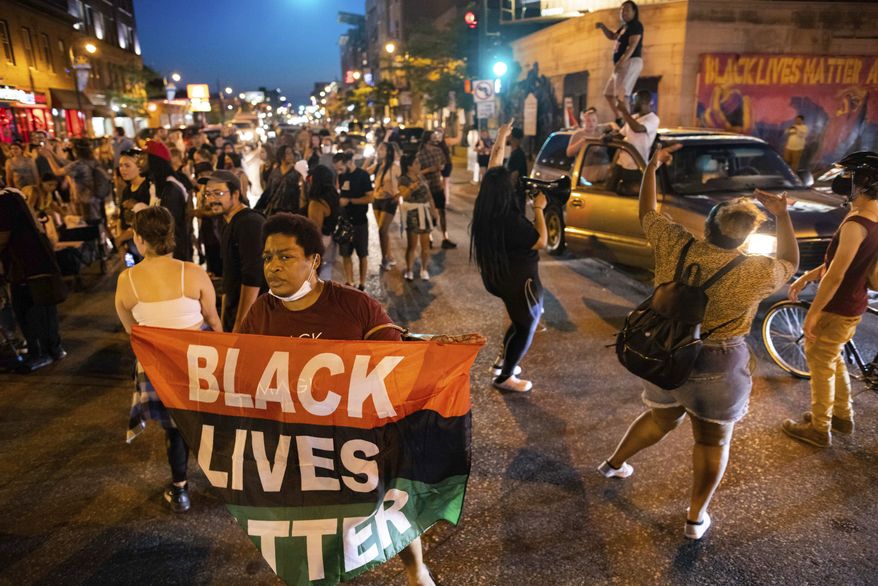 People dance in the streets and hold flags during a march for Winston Boogie Smith Jr. on Saturday, June 5, 2021, in Minneapolis. Smith was fatally shot Thursday by members of a U.S. Marshals task force.. (AP Photo/Christian Monterrosa)