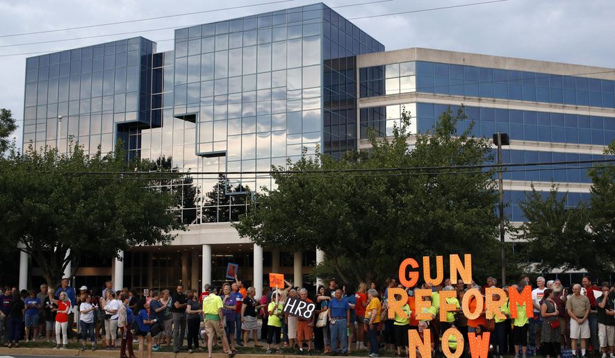 FILE - In this Aug. 5, 2019, file photo, people gather at a vigil for recent victims of gun violence outside the National Rifle Association&#39;s headquarters building in Fairfax, Va. The NRA has been embroiled in a legal and financial battle that liberals have cheered as the potential downfall of the powerful gun rights lobby, opening up a wide path for reform. Not so fast. While the battle over gun rights is shifting from Washington to the states, the NRA’s message has become so solidified in the Republican political fabric that it’s self-sustaining, even if the gun rights organization that led the way ceases to exist, leaders on both sides say. (AP Photo/Patrick Semansky, File)
