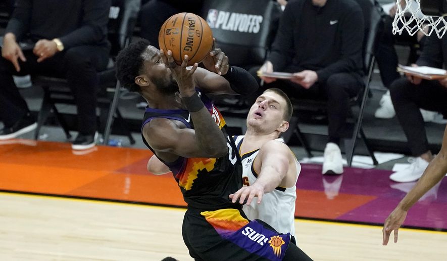 Phoenix Suns center Deandre Ayton is fouled by Denver Nuggets center Nikola Jokic, right, during the second half of Game 1 of an NBA basketball second-round playoff series, Monday, June 7, 2021, in Phoenix. (AP Photo/Matt York) **FILE**