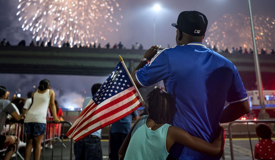 FILE - In this July 4, 2018 file photo, Deon Stewart and his daughter Semiyah, of New York, join other spectators as they watch a fireworks display on the east side of Manhattan, part of Independence Day festivities in New York. The Macy&#39;s Fourth of July fireworks show will return to New York City this year. (AP Photo/Craig Ruttle, File)