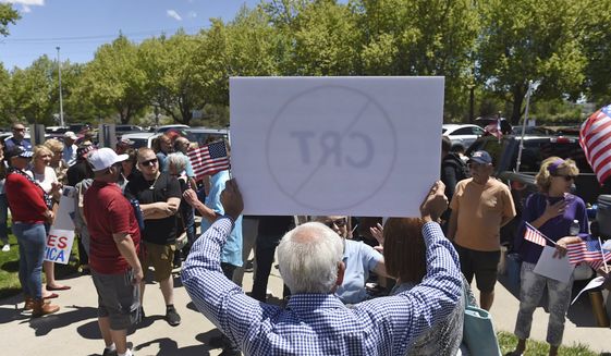 A man holds up a sign against Critical Race Theory during a protest outside a Washoe County School District board meeting on May 25, 2021, in Reno, Nev. Nevada school boards are becoming hotbeds of political polarization where parents are clashing over how to teach students about racism and its role in U.S. history. In Washoe County and Carson City, parents spoke Tuesday, June 8, 2021, against the concept of critical race theory being taught in schools, despite the fact that officials in both districts insist they have no plans to include it in lesson plans. (Andy Barron/Reno Gazette-Journal via AP) **FILE**