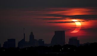 A partial solar eclipse rises over the Baltimore skyline, Thursday, June 10, 2021, seen from Arbutus, Md. (AP Photo/Julio Cortez)