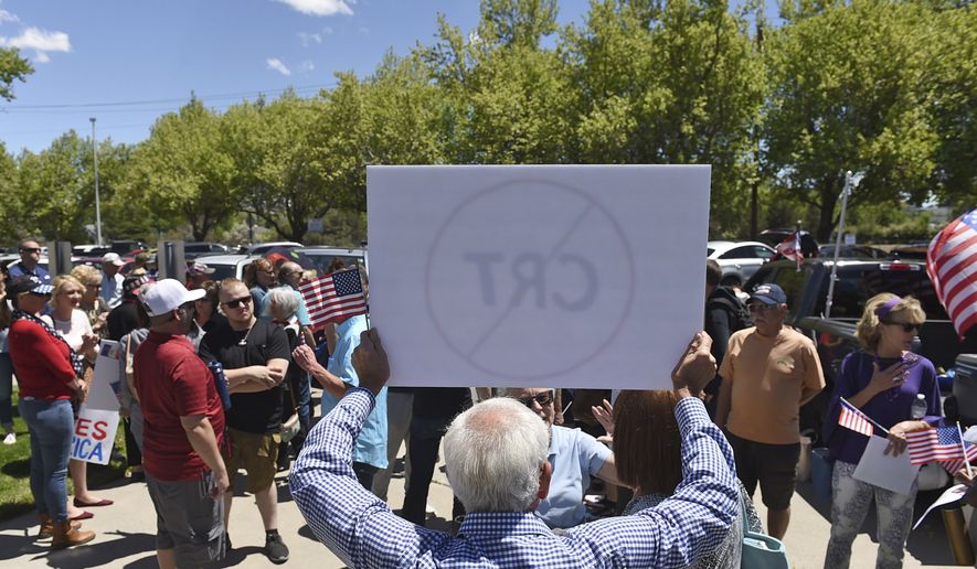 In this May 25, 2021, file photo, a man holds up a sign against critical race theory during a protest outside a Washoe County School District board meeting in Reno, Nev.  (Andy Barron/Reno Gazette-Journal via AP)  **FILE**