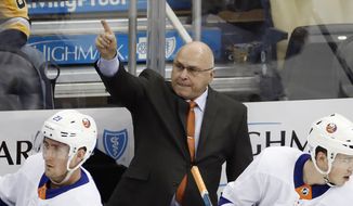 New York Islanders head coach Barry Trotz stands behind his bench during the first period of an NHL hockey game against the Pittsburgh Penguins in Pittsburgh, in this Tuesday, Nov. 19, 2019, file photo. The four coaches left in the NHL playoffs have connections to each other, but they all took different paths to get to this point. (AP Photo/Gene J. Puskar, File) **FILE**