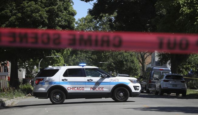 Police tape marks off a Chicago street as officers investigate the scene of a fatal shooting in the city&#x27;s South Side on Tuesday, June 15, 2021. An argument in a house erupted into gunfire early Tuesday, police said. (AP Photo/Teresa Crawford)