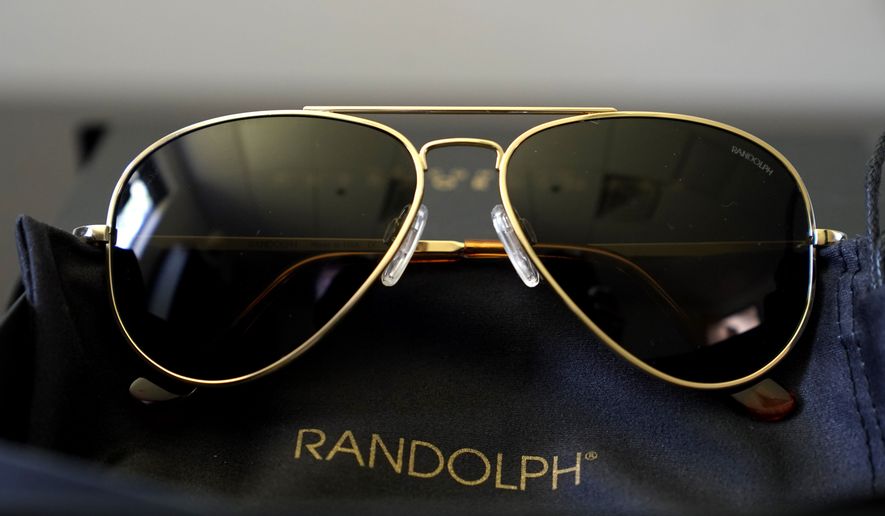 A pair of Randolph Engineering Concorde teardrop sunglasses, in 23-karat gold finish with polarized American gray lenses, rest on a table at the company where they are made, in Randolph, Mass., Thursday, June 17, 2021. Russian President Vladimir Putin received a pair of the sunglasses from President Joe Biden following their meeting in Switzerland this week. (AP Photo/Steven Senne)