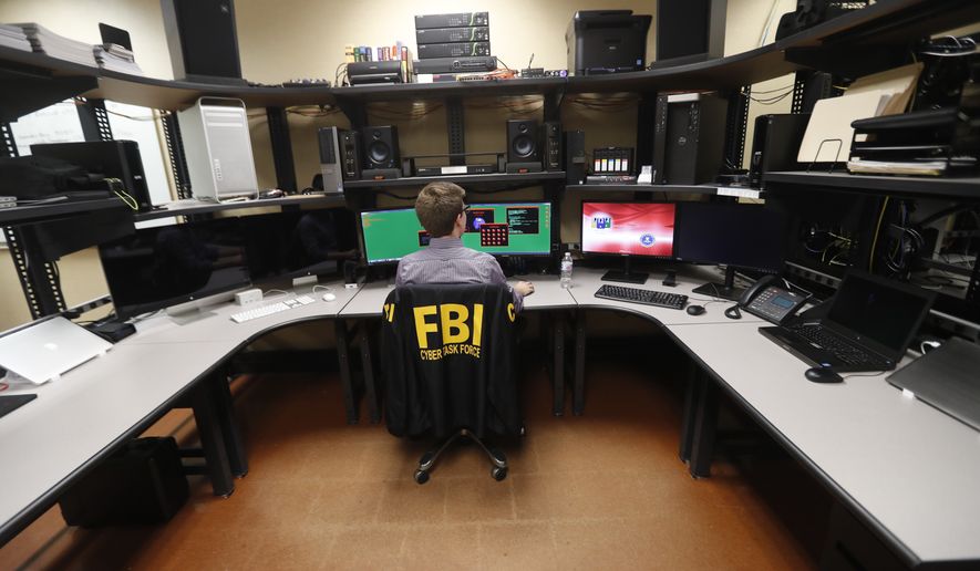 In this Tuesday, July 31, 2018, photo, an FBI employee works in a computer forensics lab at the FBI field office in New Orleans. More than 20 people working for the FBI headquarters in Louisiana are working on cyber security. They include experts working at forensics labs, doing forensics on computer hard drives and developing techniques for analyzing computer memories in efforts to fight and find intruders, according to the special agent in charge of the FBI&#39;s New Orleans field office. (AP Photo/Gerald Herbert)