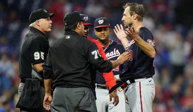Washington Nationals pitcher Max Scherzer, right, is checked for foreign substances during the middle of the fourth inning of a baseball game against the Philadelphia Phillies, Tuesday, June 22, 2021, in Philadelphia. (AP Photo/Matt Slocum)