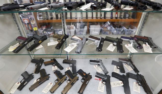 In this March 25, 2020, file photo semi-automatic handguns are displayed at shop in New Castle, Pa. Firearm purchases by a record number of Black Americans have accelerated a surge in gun sales since the pandemic, according to an analysis of government records. (AP Photo/Keith Srakocic, File)