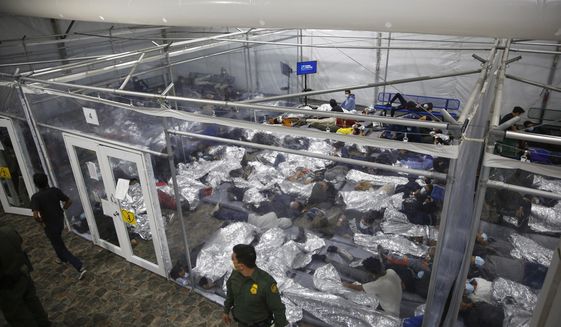 In this March 30, 2021, file photo, young minors lie inside a pod at the Donna Department of Homeland Security holding facility, the main detention center for unaccompanied children in the Rio Grande Valley run by U.S. Customs and Border Protection (CBP), in Donna, Texas. (AP Photo/Dario Lopez-Mills, Pool) ** FILE **