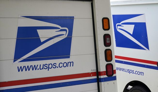 In this Aug. 18, 2020, photo, mail delivery vehicles are parked outside a post office in Boys Town, Neb. (AP Photo/Nati Harnik) **FILE**