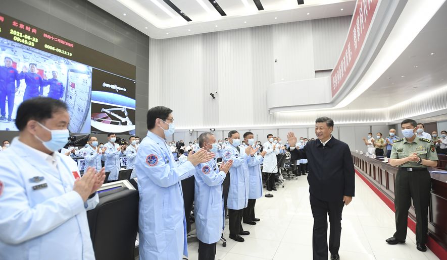 In this photo released by China&#39;s Xinhua News Agency, Chinese President Xi Jinping greets workers after having a video conversation with the three astronauts aboard China&#39;s space station core module Tianhe at the Beijing Aerospace Control Center in Beijing, Wednesday, June 23, 2021. (Yan Yan/Xinhua via AP)  **FILE**
