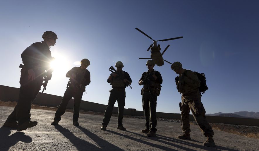 In this Nov. 30, 2017, file photo, American soldiers wait on the tarmac in Logar province, Afghanistan. With American troops withdrawing from Afghanistan, pressure has been mounting for the Biden administration to plan a military evacuation of Afghans who supported U.S. military operations during two decades of war in their country. (AP Photo/Rahmat Gul, File)