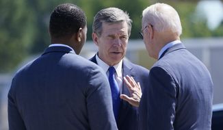 In this file photo, President Joe Biden talks with North Carolina Gov. Roy Cooper and EPA Administrator Michael Regan, after arriving at Raleigh-Durham International Airport, Raleigh, N.C., Thursday, June 24, 2021. (AP Photo/Susan Walsh)