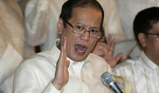 In this June 30, 2010, file photo, then newly inaugurated Philippine President Benigno Aquino III, center, swears in local officials during his first day at the Malacanang presidential palace in Manila, Philippines. Aquino, the son of pro-democracy icons who helped topple dictator Ferdinand Marcos and had troublesome ties with China, died Thursday, June 24, 2021, a cousin and public officials said.  (AP Photo/Aaron Favila, File)