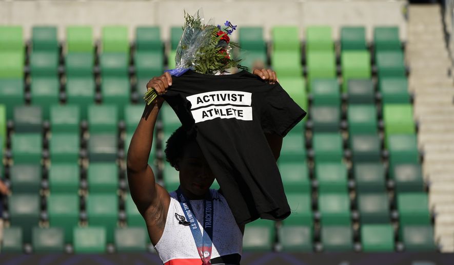 Gwendolyn Berry her Activist Athlete T-Shirt over her head during the metal ceremony after the finals of the women&#39;s hammer throw at the U.S. Olympic Track and Field Trials Saturday, June 26, 2021, in Eugene, Ore. Berry finished third. (AP Photo/Charlie Riedel)