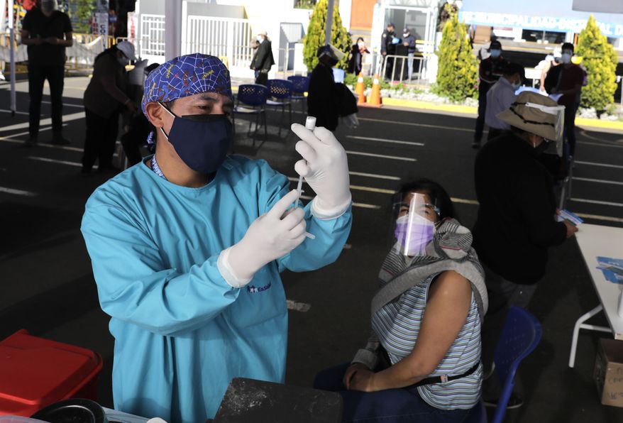 A health care worker prepares a dose of the Pfizer COVID-19 vaccine at a vaccination site, in Arequipa, Peru, Saturday, June 26, 2021. Due to increased cases of COVID-19 and the delta variant of the disease, the city is under a strict lockdown for 15 days beginning June 21. (AP Photo/Guadalupe Pardo)