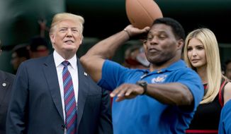In this May 29, 2018, file photo, President Donald Trump, left, and his daughter Ivanka Trump, right, watch as former football player Herschel Walker, center, throws football&#39;s during White House Sports and Fitness Day on the South Lawn of the White House in Washington. The U.S. Senate nomination in a premier battleground like Georgia should be a plum political prize, but a year before Republican voters choose a nominee for the 2022 midterms, they have no clear options. The wildcard is whether football hero Herschel Walker runs and brings the endorsement of former President Donald Trump. (AP Photo/Andrew Harnik)