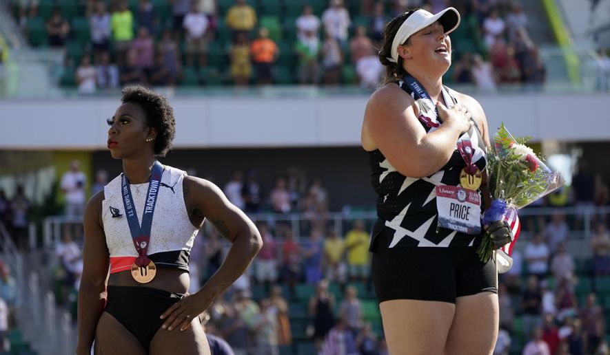 Gwendolyn Berry, left, looks away as DeAnna Price stands for the national anthem after the finals of the women&#39;s hammer throw at the U.S. Olympic Track and Field Trials Saturday, June 26, 2021, in Eugene, Ore. Price won and Berry finished third. (AP Photo/Charlie Riedel)