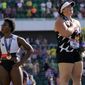 Gwendolyn Berry, left, looks away as DeAnna Price stands for the national anthem after the finals of the women&#39;s hammer throw at the U.S. Olympic Track and Field Trials Saturday, June 26, 2021, in Eugene, Ore. Price won and Berry finished third. (AP Photo/Charlie Riedel)
