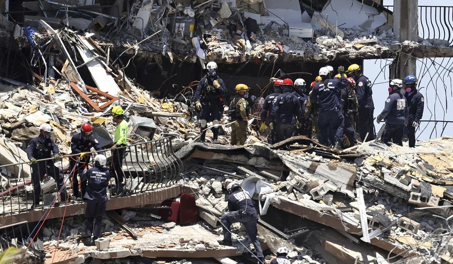 Search and rescue personnel search for survivors through the rubble at the Champlain Towers South in Surfside, Fla., Sunday, June 27, 2021. The apartment building partially collapsed on Thursday, June 24. (David Santiago/Miami Herald via AP)