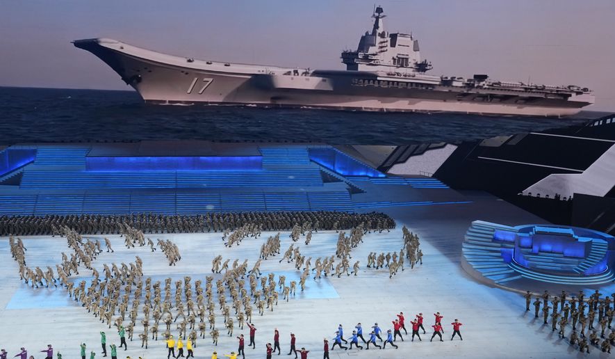 In this file photo, China&#x27;s military personnel perform near a display showing the navy&#x27;s aircraft carrier in a segment of a gala show ahead of the 100th anniversary of the founding of the Chinese Communist Party in Beijing on Monday, June 28, 2021. The Chinese Communist Party makes no secret of its goal to build a &quot;world-class&quot; military by 2050, and U.S. analysts are increasingly wary that Washington may struggle to keep pace with China&#x27;s rapidly expanding shipbuilding operations. (AP Photo/Ng Han Guan) **FILE**