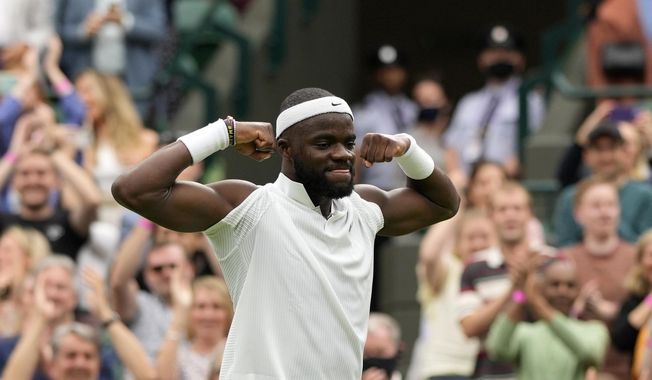 Frances Tiafoe of the US celebrates after winning the men&#x27;s singles match against Stefanos Tsitsipas of Greece on day one of the Wimbledon Tennis Championships in London, Monday June 28, 2021. (AP Photo/Alastair Grant)