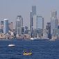 Kayakers and boaters ply the waters of Elliott Bay with the Seattle skyline behind during a heat wave hitting the Pacific Northwest, Sunday, June 27, 2021. The day before set a record high for the day with more record highs expected today and Monday. (AP Photo/John Froschauer)
