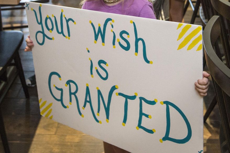 In this Thursday, Aug. 22, 2019, file photo, a girl holds a sign while waiting for her cousin to arrive for a surprise Make-A-Wish announcement in Rogers, Ark. In June 2021, the Make-a-Wish Foundation is disputing what it calls a “misinformation” campaign about whether children who aren't vaccinated against COVID-19 will be eligible to have their wishes granted. (Ben Goff/The Northwest Arkansas Democrat-Gazette via AP) ** FILE **