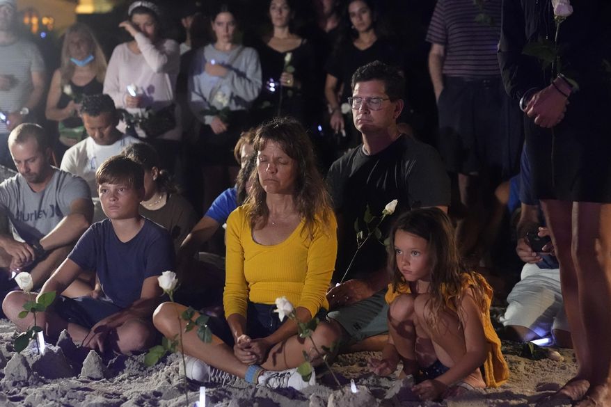 People gather at a vigil, late Monday, June 28, 2021, in Surfside, Fla. The vigil remembered those that died, are missing and those injured after a residential building collapsed last Thursday. (AP Photo/Marta Lavandier)