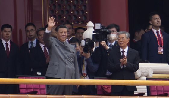 Chinese President Xi Jinping, center, waves next to former President Hu Jintao, right, during a ceremony to mark the 100th anniversary of the founding of the ruling Chinese Communist Party at Tiananmen Gate in Beijing Thursday, July 1, 2021. (AP Photo/Ng Han Guan) ** FILE **