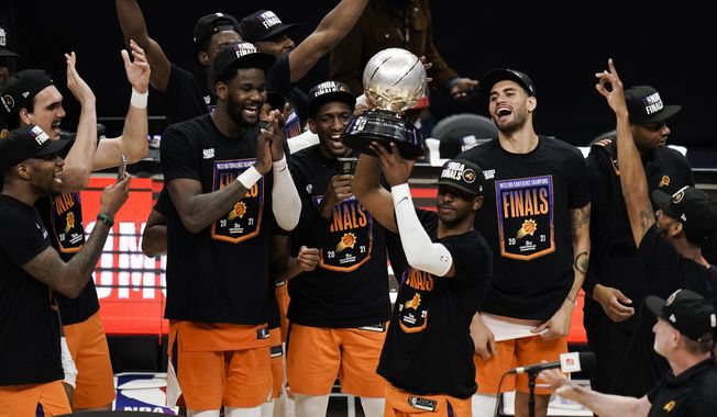 Phoenix Suns&#x27; Chris Paul hoists the trophy as he and his teammates celebrate after defeating the Los Angeles Clippers in Game 6 of the NBA basketball Western Conference Finals Wednesday, June 30, 2021, in Los Angeles. (AP Photo/Jae C. Hong) **FILE**