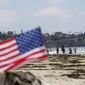 People walk along La Jolla Shores beach as Independence Day weekend nears, Thursday, July 1, 2021, in San Diego. Holiday travel over the Independence Day weekend is expected to nearly return to pre-pandemic levels, according to AAA. (AP Photo/Gregory Bull)