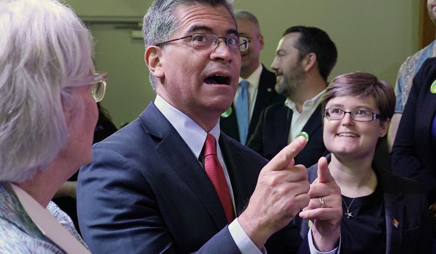 U.S. Department of Health and Human Services (HHS) Secretary Xavier Becerra, center, talks with with Oklahoma Medicaid advocates following a news conference Thursday, July 1, 2021, in Tulsa, Okla., as Oklahoma expands its Medicaid program. (AP Photo/Sue Ogrocki)
