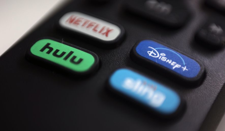 In this Aug. 13, 2020, file photo, the logos for Netflix, Hulu, Disney Plus and Sling TV are pictured on a remote control in Portland, Ore. (AP Photo/Jenny Kane)