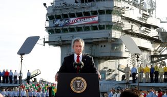 In this file photo, President Bush declares the end of major combat in Iraq as he speaks aboard the aircraft carrier USS Abraham Lincoln off the California coast, in this May 1, 2003 file photo.  More than 18 years later, the legislation authorizing the Persian Gulf War and the Iraq War remain on the books. The Senate Foreign Relations Committee met on August 3, 2021, to grapple with a measure to repeal the 1991 and 2002 Authorizations for the Use of Military Force (AUMF), which provided the legal justification for the Gulf War and the 2003 invasion of Iraq.   (AP Photo/J. Scott Applewhite, File)