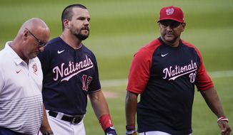 Washington Nationals&#39; Kyle Schwarber, center, hobbles off the field next to trainer Paul Lessard, left, and manager Dave Martinez during the second inning of a baseball game against the Los Angeles Dodgers, Friday, July 2, 2021, in Washington. (AP Photo/Julio Cortez)