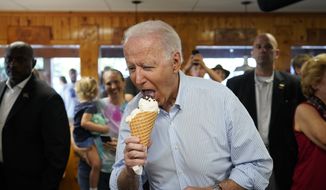 President Joe Biden eats ice cream as he visits Moomers Homemade Ice Cream, Saturday, July 3, 2021, in Traverse City, Mich. (AP Photo/Alex Brandon)