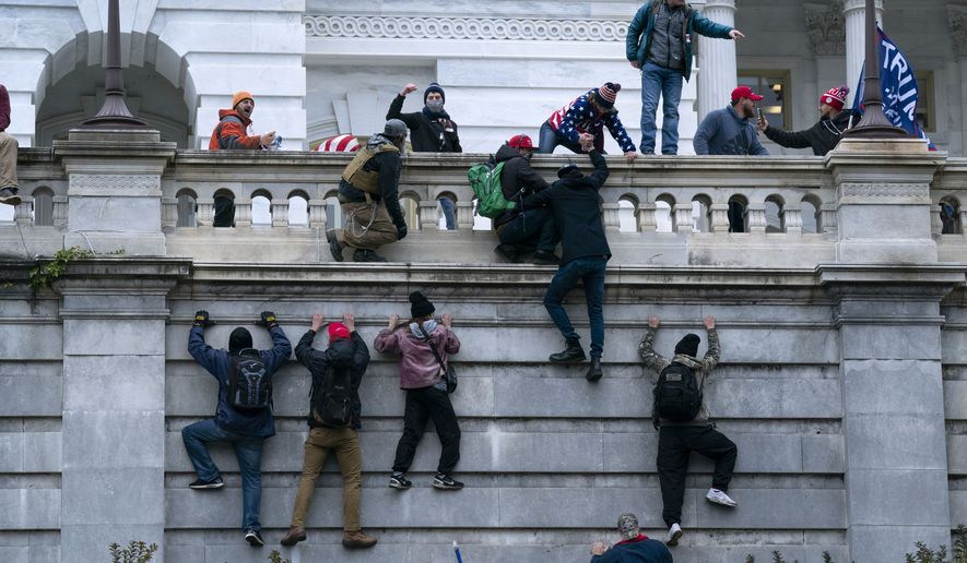 FILE - In this Jan. 6, 2021 file photo, violent insurrectionists loyal to President Donald Trump scale the west wall of the the U.S. Capitol in Washington.  (AP Photo/Jose Luis Magana, File)