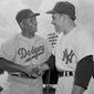 Brooklyn Dodgers&#x27; Roy Campanella, left, and New York Yankees&#x27; Yogi Berra, rival catchers, exchanged greetings before an exhibition game on March 25, 1955.(AP Photo) **FILE**