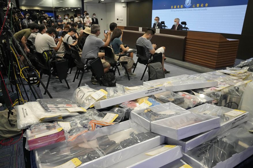 Police hold a news conference with confiscated evidence seen at front, the police headquarters in Hong Kong, Tuesday, July 6, 2021. Hong Kong police on Tuesday said they arrested nine people on suspicion of engaging in terrorist activity, after uncovering an attempt to make explosives and plant bombs across the city. Of the nine arrested, six are secondary school students, police said. (AP Photo/Kin Cheung)