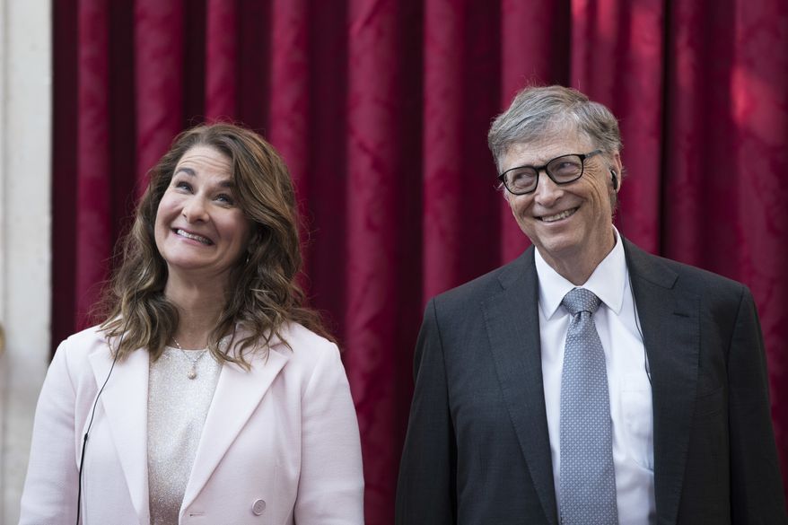 FILE - In this April 21, 2017, file photo, Philanthropist and co-founder of Microsoft, Bill Gates, right, and his wife Melinda react, prior to being awarded the Legion of Honour at the Elysee Palace in Paris.   Bill Gates and Melinda French Gates will continue to work together as co-chairs of their foundation even after their planned divorce. However, if after two years they cannot continue in their roles, French Gates will resign her positions as co-chair and trustee, The Bill and Gates Melinda Foundation announced Wednesday, July 7, 2021.  (AP Photo/Kamil Zihnioglu, Pool)