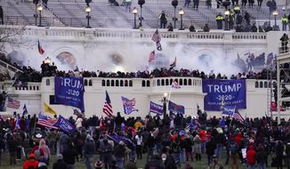 In this Jan. 6, 2021, file photo, violent protesters, loyal to then-President Donald Trump, storm the Capitol, Wednesday, Jan. 6, 2021, in Washington. Two Seattle police officers who were in Washington, D.C., during the January 6 insurrection were illegally trespassing on Capitol grounds while rioters stormed the building, but lied about their actions, a police watchdog said in a report released Thursday, July 8, 2021. (AP Photo/John Minchillo, File)